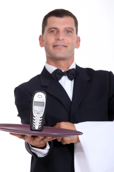 Waitor giving phone on a plate — Stock Photo, Image