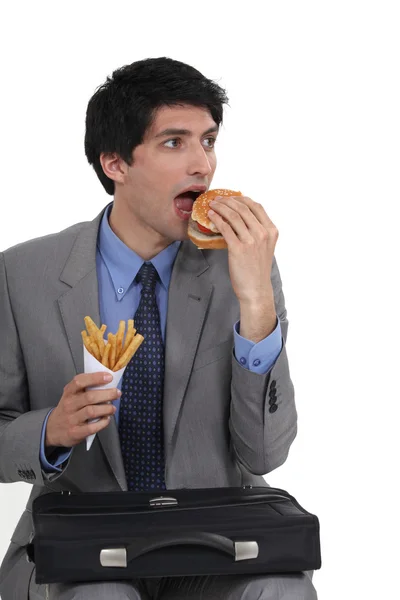 Empresario comiendo comida chatarra —  Fotos de Stock