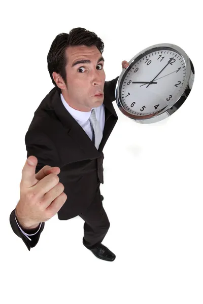 Uomo d'affari in fretta tenendo un orologio enorme — Foto Stock