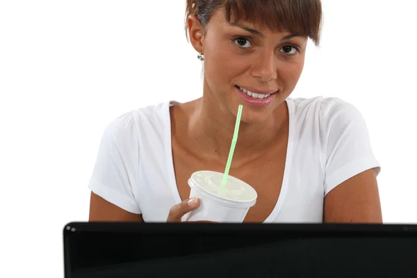 Žena s nápojem a počítač — Stock fotografie