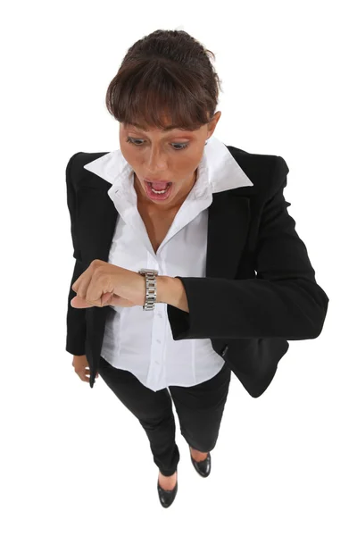 Donna d'affari che guarda il suo orologio in allarme Immagini Stock Royalty Free