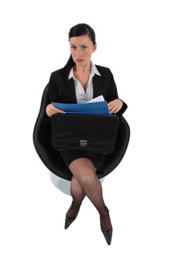 Businesswoman reviewing her files before a meeting clipart