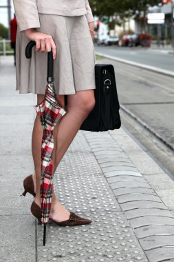 Stylish woman waiting to cross the street clipart