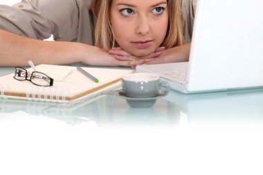Woman peering at her laptop clipart