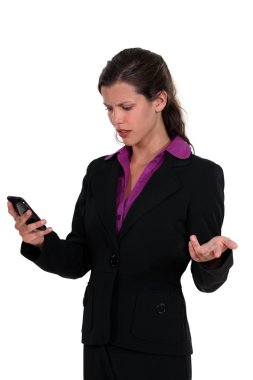 Angry woman reading a text message clipart