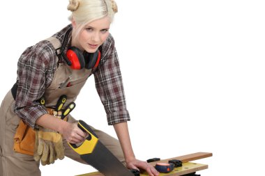 A female carpenter sawing. clipart