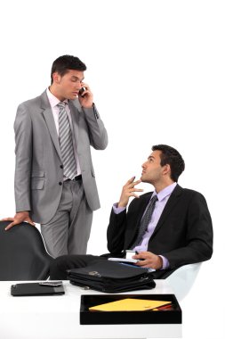 Businessmen patiently waiting for their client to arrive at a meeting clipart