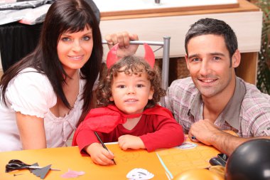 Little boy and parents getting ready for Halloween clipart