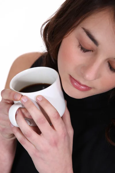Mujer sosteniendo taza de café a la cara — Foto de Stock