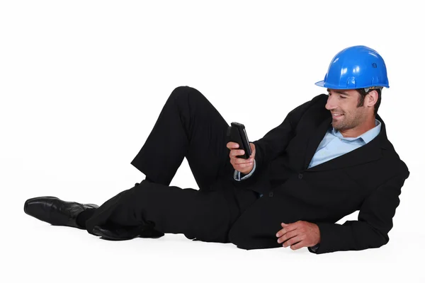Архітектор лежить на підлозі з мобільним — стокове фото