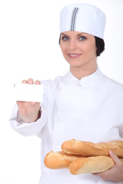 Female bakery worker with business card — Stock Photo, Image