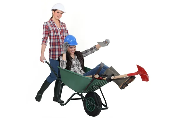 Two women messing around wuth wheelbarrow — Stock Photo, Image
