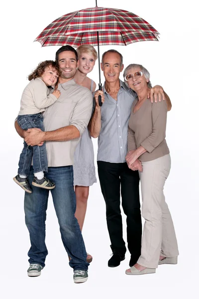 Smiling family under an umbrella — Stock Photo, Image