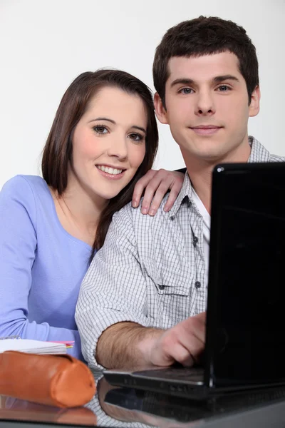 Um casal de estudantes trabalhando em seu laptop . — Fotografia de Stock
