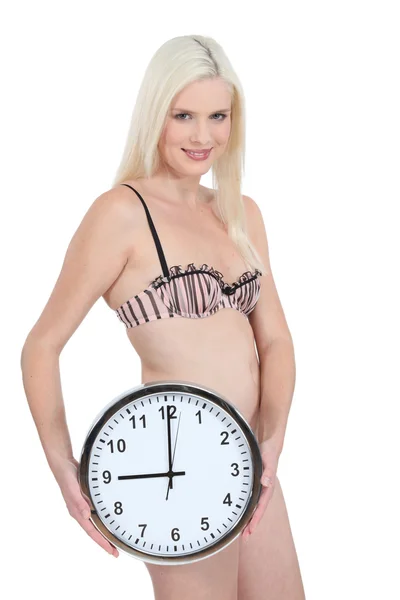 Femme en sous-vêtements avec une horloge montrant 9 : 00 — Photo