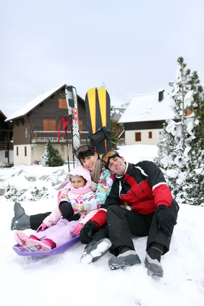Family of skiers sat by chalet — Stock Photo, Image