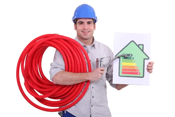 Fontanero sosteniendo un grifo y una etiqueta de consumo de energía — Foto de Stock