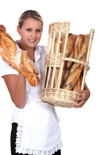 Bakery worker holding basket of bread — Stock Photo, Image