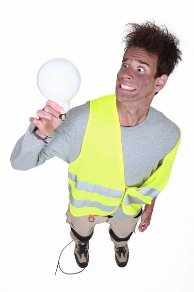 Шокований чоловік тримає лампочку — стокове фото