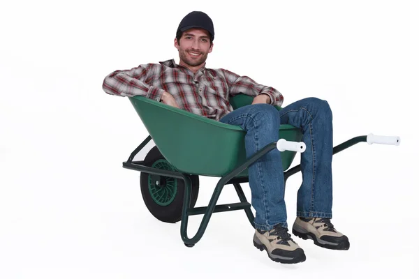 A man resting in a wheelbarrow. — Stock Photo, Image