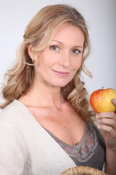 Frau hält Apfel. — Stockfoto