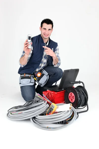 Elektriker zeigt auf sein Handy — Stockfoto