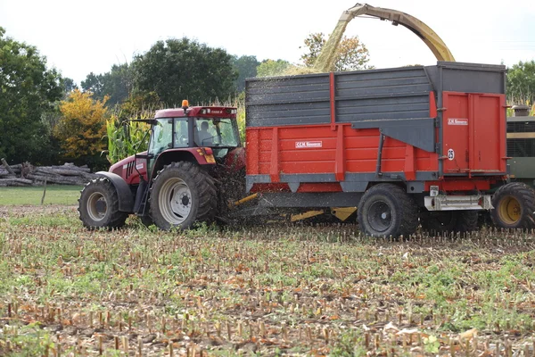Трактор тягне причіп через поле — стокове фото