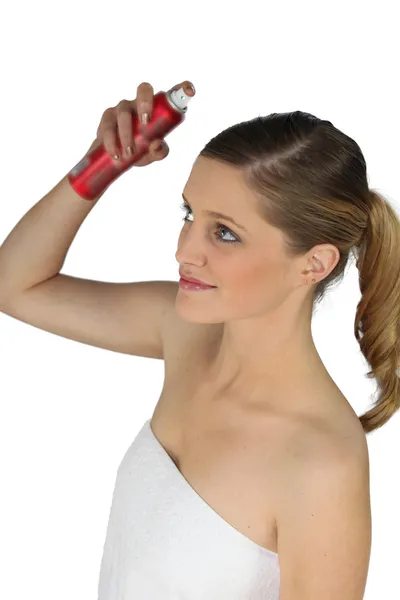 Mulher pulverizando seu cabelo com spray de cabelo — Fotografia de Stock