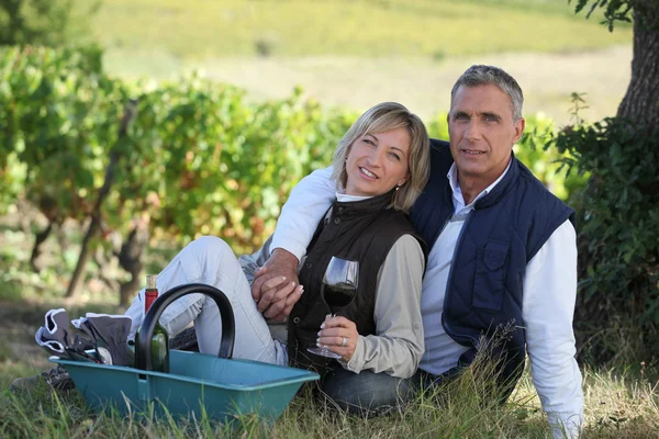 Couple sitting in front of vineyard — Stock Photo, Image