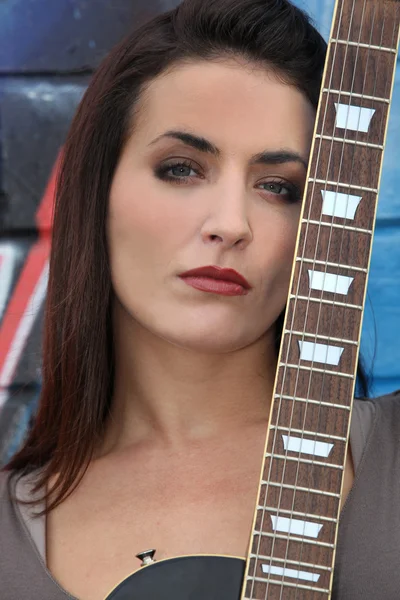 Bruneta žena s krku kytary — Stock fotografie