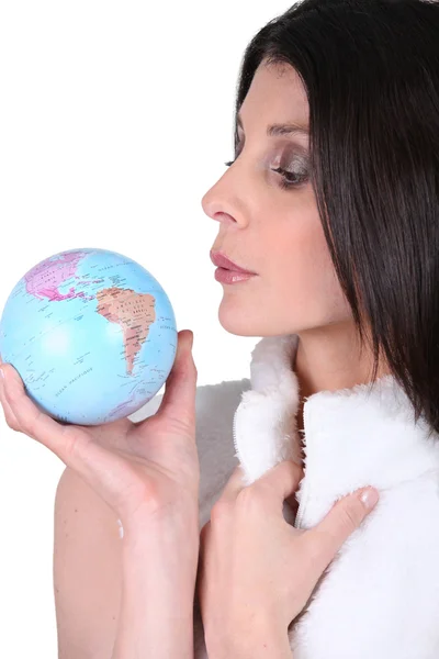 Woman blowing on a mini globe — Stock Photo, Image