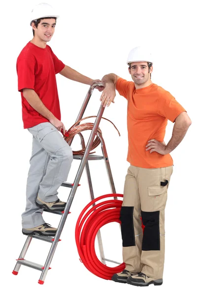 Dos electricistas con bobina de cobre y escalera — Foto de Stock