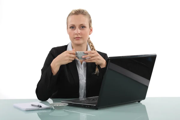 Uma mulher de negócios tomando uma xícara de café em seu escritório . — Fotografia de Stock