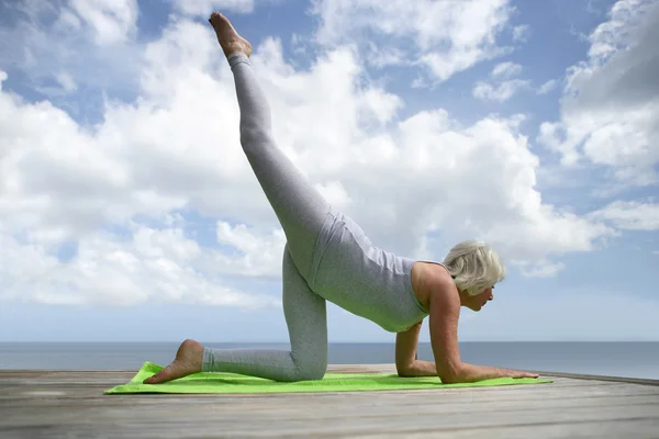 Mature woman practicing yoga — Stock Photo, Image