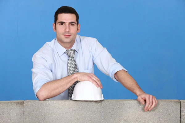 Engineer standing by a block wall — Stock Photo, Image