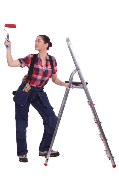 Mujer con rodillo de pintura en pie por escalera —  Fotos de Stock