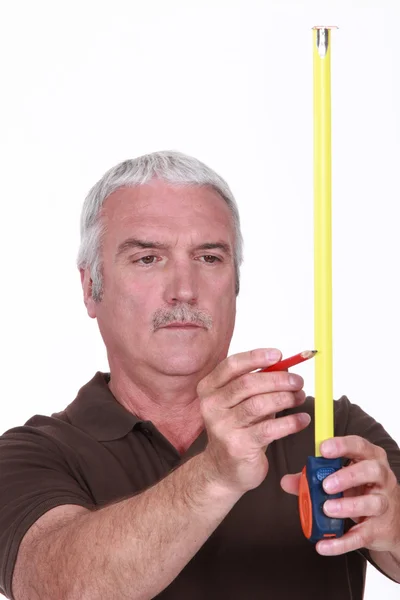 Hombre usando cinta métrica y lápiz — Foto de Stock