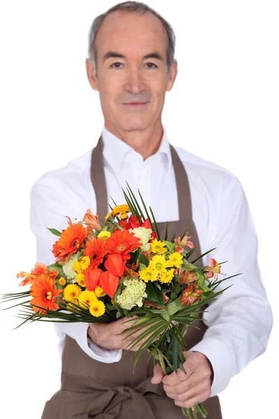 Senior florist håller en bukett — Stockfoto