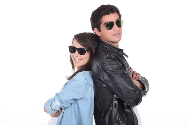Jovem casal vestindo óculos de sol e roupas da moda — Fotografia de Stock