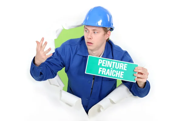 Decorator with a wet paint sign in French — Stock Photo, Image