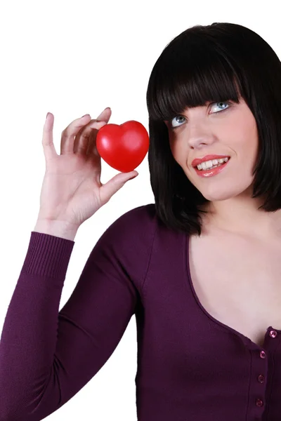 Küçük, kırmızı bir kalp tutan genç kadın — Stok fotoğraf