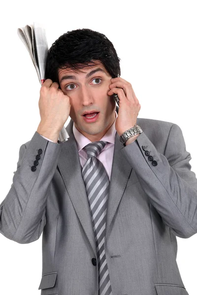 Young elegant businessman holding newspaper makes a call — Stock Photo, Image