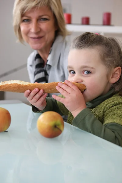Klein meisje eten brood — Stockfoto