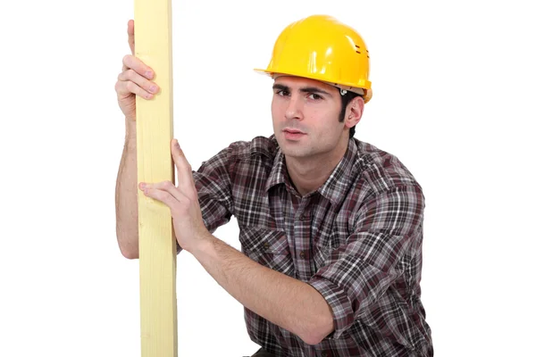 Man examining plank of wood — Stock Photo, Image