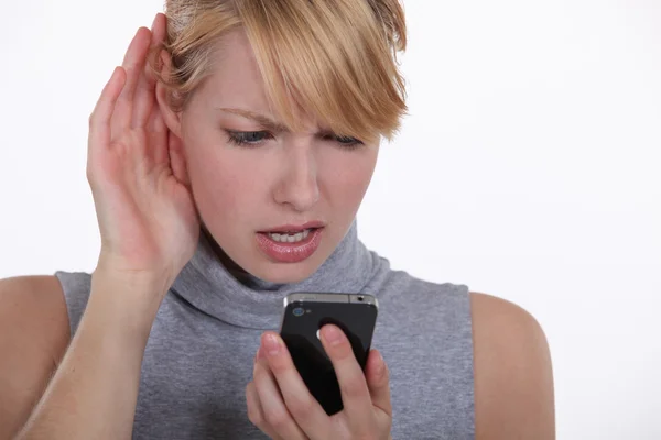 Vrouw die worstelt om een gesprek op de telefoon met luidspreker — Stockfoto
