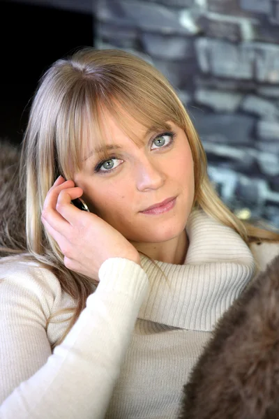 Woman sat on sofa making a call — Stock Photo, Image