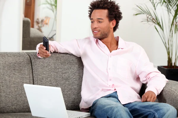Чоловік сидів удома з ноутбуком і мобільним — стокове фото