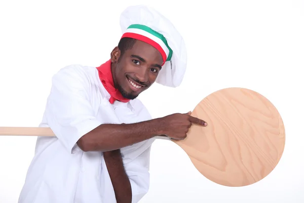 Fabricante de pizza apontando para uma casca de pizza — Fotografia de Stock
