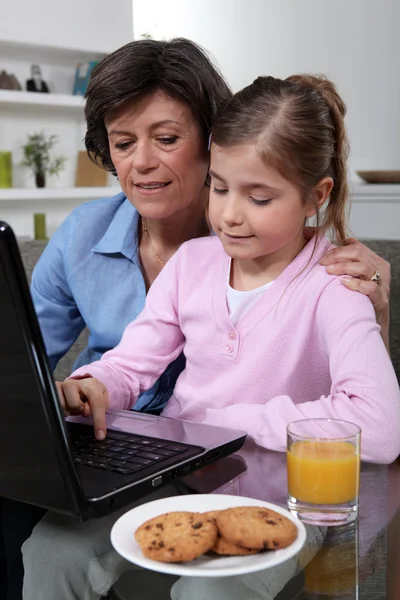 Moeder en dochter zat op laptop — Stockfoto