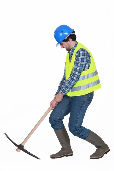 Worker struggling to lift axe — Stockfoto